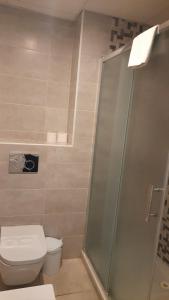 a bathroom with a toilet and a glass shower at Sal Mar Suites in Santa Eularia des Riu