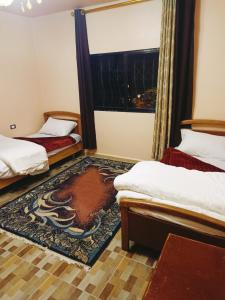 um quarto com duas camas e uma janela em Jordanian Baity Apartment em Wadi Musa