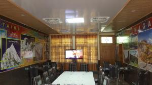 a conference room with tables and chairs and a television at Hikal Guest House in Hunza Valley