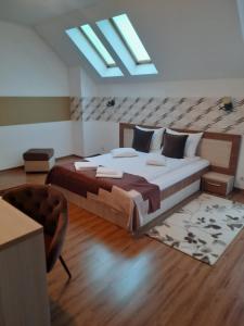 a bedroom with a large bed and a skylight at Villa Prestige in Sovata