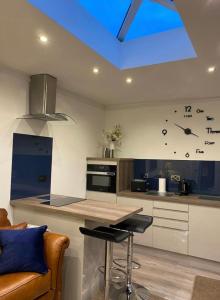 una cocina con reloj en la pared en Balcony House Apartment in Kendal, en Kendal