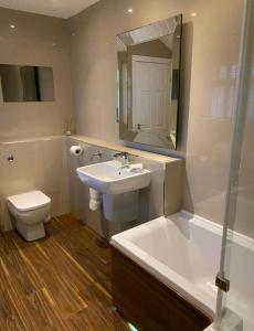 a bathroom with a sink and a toilet and a tub at Balcony House Apartment in Kendal in Kendal