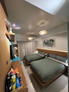 a bedroom with two beds and a television in it at Suēlo at Cool Suites at Wind Residences Tagaytay in Tagaytay