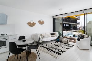 a living room with a couch and a table and chairs at Bright & Chic Condo with Pool & Unique View by FeelHome in Tel Aviv
