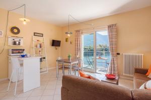 Lake Como Apartment with Balcony and Private Parking في Ossuccio: غرفة معيشة مع أريكة ومطبخ مع شرفة