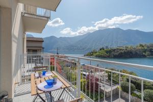 Lake Como Apartment with Balcony and Private Parking في Ossuccio: شرفة مطلة على المياه والجبال