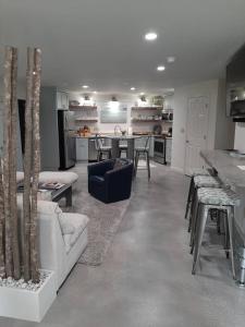 a living room with a couch and a table with chairs at 5 Star Waterfront Luxury Vacation Apartment in New London