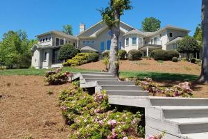 a large house with flowers in the front yard at 5 Star Waterfront Luxury Vacation Apartment in New London