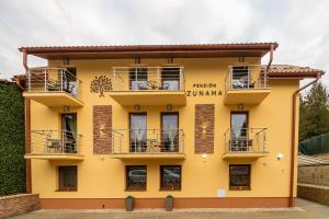 - un bâtiment jaune avec balcon dans l'établissement Penzión Zunama, à Bardejovské Kúpele