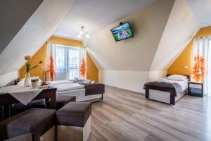 a room with two beds and a tv on the wall at Budzowy Dworek in Murzasichle