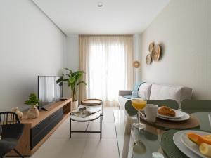 una sala de estar con una mesa con comida. en Royal Suites, en Las Palmas de Gran Canaria