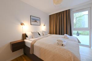 a bedroom with a large bed with two towels on it at Aura 40 by Q4Apartments in Gdańsk