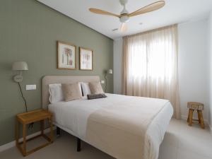 a bedroom with a white bed and a ceiling fan at Royal Suites in Las Palmas de Gran Canaria