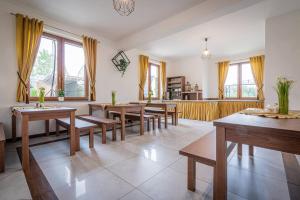 a dining room with wooden tables and benches at Budzowy Dworek in Murzasichle