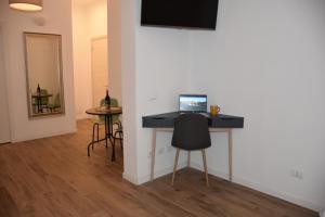 a room with a desk with a laptop on a wall at R & A Minerva Suites in Pavia