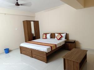 a bedroom with a bed and a table in it at PREMIER INN LODGE in Mangalore +15 photos