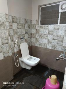 a bathroom with a white toilet and a window at PREMIER INN LODGE in Mangalore