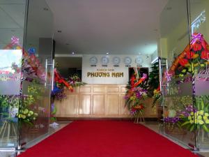 a room with a red carpet and a sign with flowers at Phuong Nam Hotel in Diện Biên Phủ