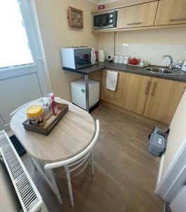 a small kitchen with a table and a microwave at Y Villa Môr in Llanarth