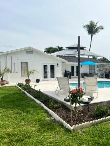 a house with a swimming pool and two chairs at Turtle Island - Family Friendly Pool Home -Welcome in Naples