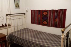 um quarto com uma cama e um cobertor na parede em Melissomandri - traditional house at Kompoti 