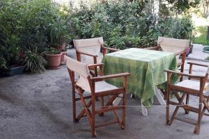 uma mesa com quatro cadeiras e uma toalha de mesa verde em Melissomandri - traditional house at Kompoti 