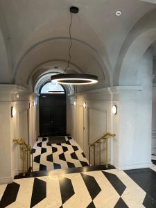 a hallway with a black door and a checkered floor at Luxury Studio in Downtown, Free Parking & Pool in Budapest