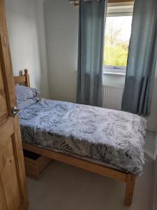 a small bed in a room with a window at Southsea in Coedpoeth