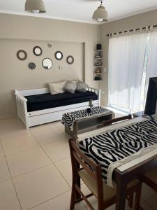 een kamer met een bed, een tafel en stoelen bij Avenida Belgrano in Salta