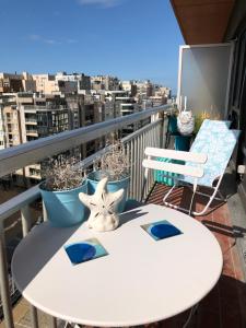 a table and chairs on a balcony with a view of a city at Ma Mère Beach Condo Oostende in Ostend