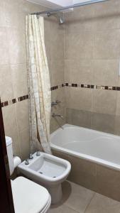 een badkamer met toilet, bad en wastafel bij Avenida Belgrano in Salta
