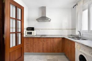 a kitchen with a sink and a microwave at Piso Fábrica - Solo Familias in Conil de la Frontera