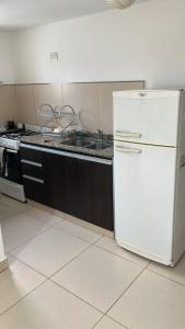 een keuken met een witte koelkast en een spoelbak bij Avenida Belgrano in Salta