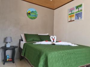 - une chambre avec un lit vert et un bunny rembourré dans l'établissement Cabinas Guayabón #4 La Fortuna Volcán Arenal, à Fortuna