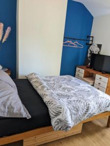 a bed in a bedroom with a blue wall at Southsea in Coedpoeth