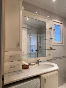 a white bathroom with a sink and a mirror at Stunning Sea View and Central Location, 2BR in Istanbul