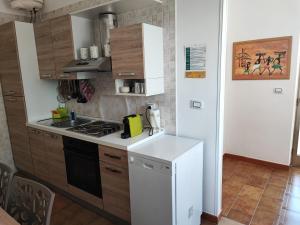 a kitchen with a stove and a white refrigerator at Casa Limone in San Pietro in Bevagna