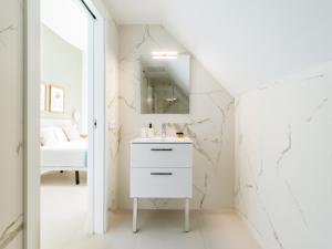 a white bathroom with a sink and a mirror at Royal Suites in Las Palmas de Gran Canaria +58 photos