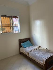 een slaapkamer met een bed in een kamer met een raam bij Holiday house in Sale