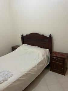 un letto con testiera in legno e comodino di Holiday house a Salé