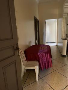um quarto com uma mesa e uma cadeira com um cobertor roxo em Holiday house em Salé