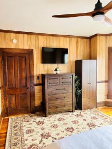 1 dormitorio con TV, vestidor y puerta en Monterey Inn, en Monterey