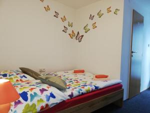 a bedroom with a bed with butterflies on the wall at Villa LIKE "garden-grill" in Bardejov