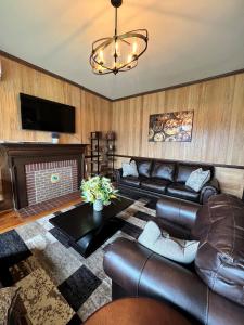 a living room with leather furniture and a fireplace at Monterey Inn in Monterey