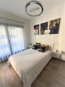 a bedroom with a large bed and a chandelier at Luxury Studio in Downtown, Free Parking & Pool in Budapest