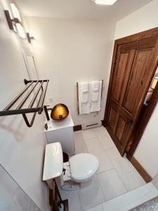 ein Badezimmer mit einem WC und einer Holztür in der Unterkunft Monterey Inn in Monterey