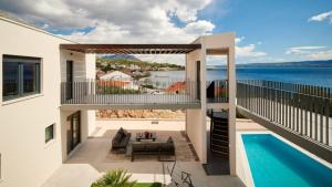 een huis met een balkon en een zwembad bij Villa AdriaStar in Dugi Rat