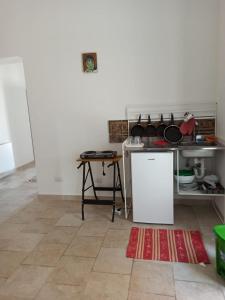 a kitchen with a table and a white refrigerator at Cara Casa al Porto n.25 in Bari