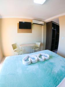 Zimmer mit einem Bett mit zwei Kissen darauf in der Unterkunft Estação do Sol Praia Hotel in Porto De Galinhas
