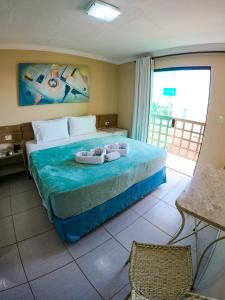 a bedroom with a bed with two towels on it at Estação do Sol Praia Hotel in Porto De Galinhas